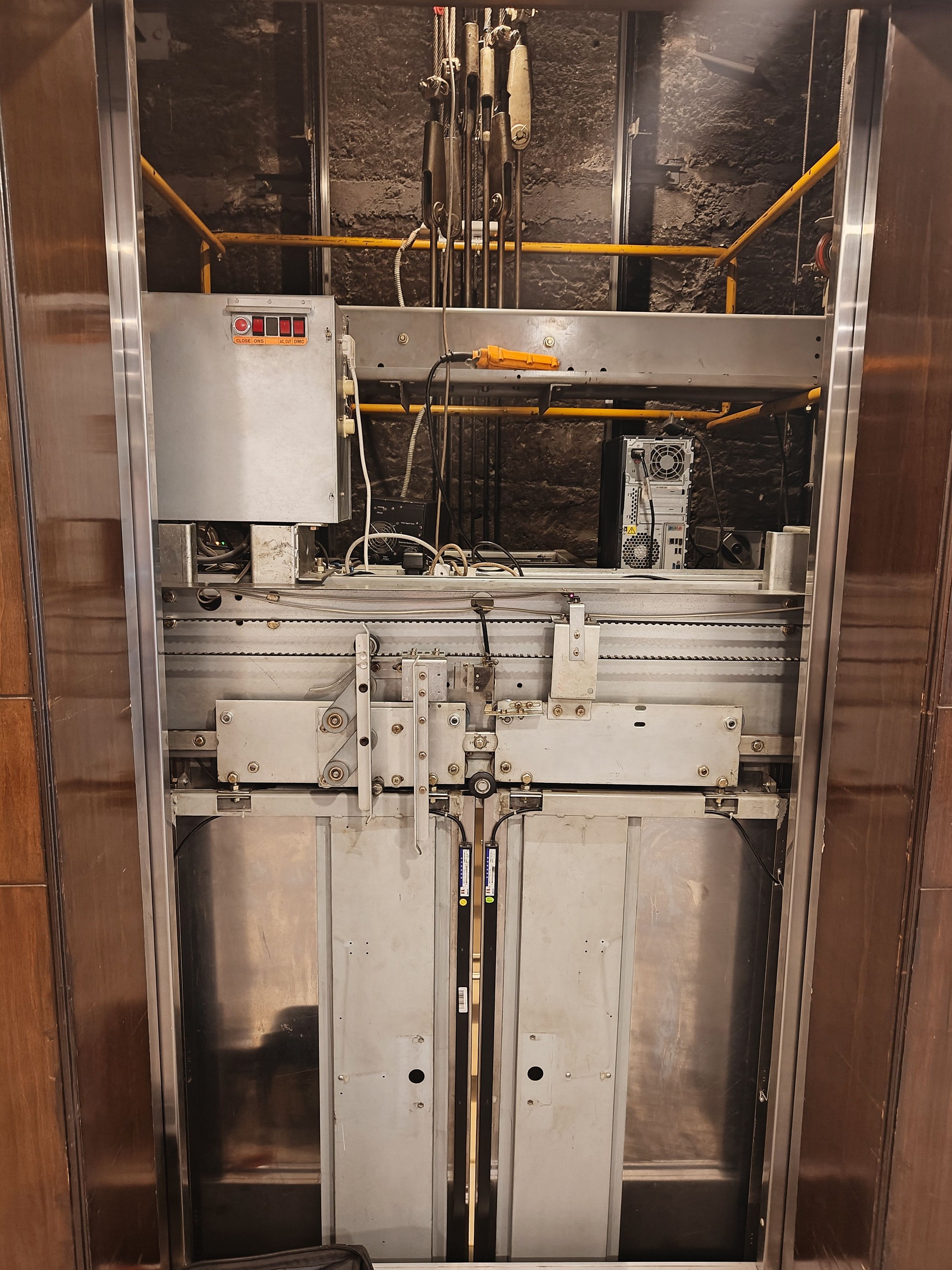Close-up of elevator machinery in a building shaft, showcasing its mechanical components and design